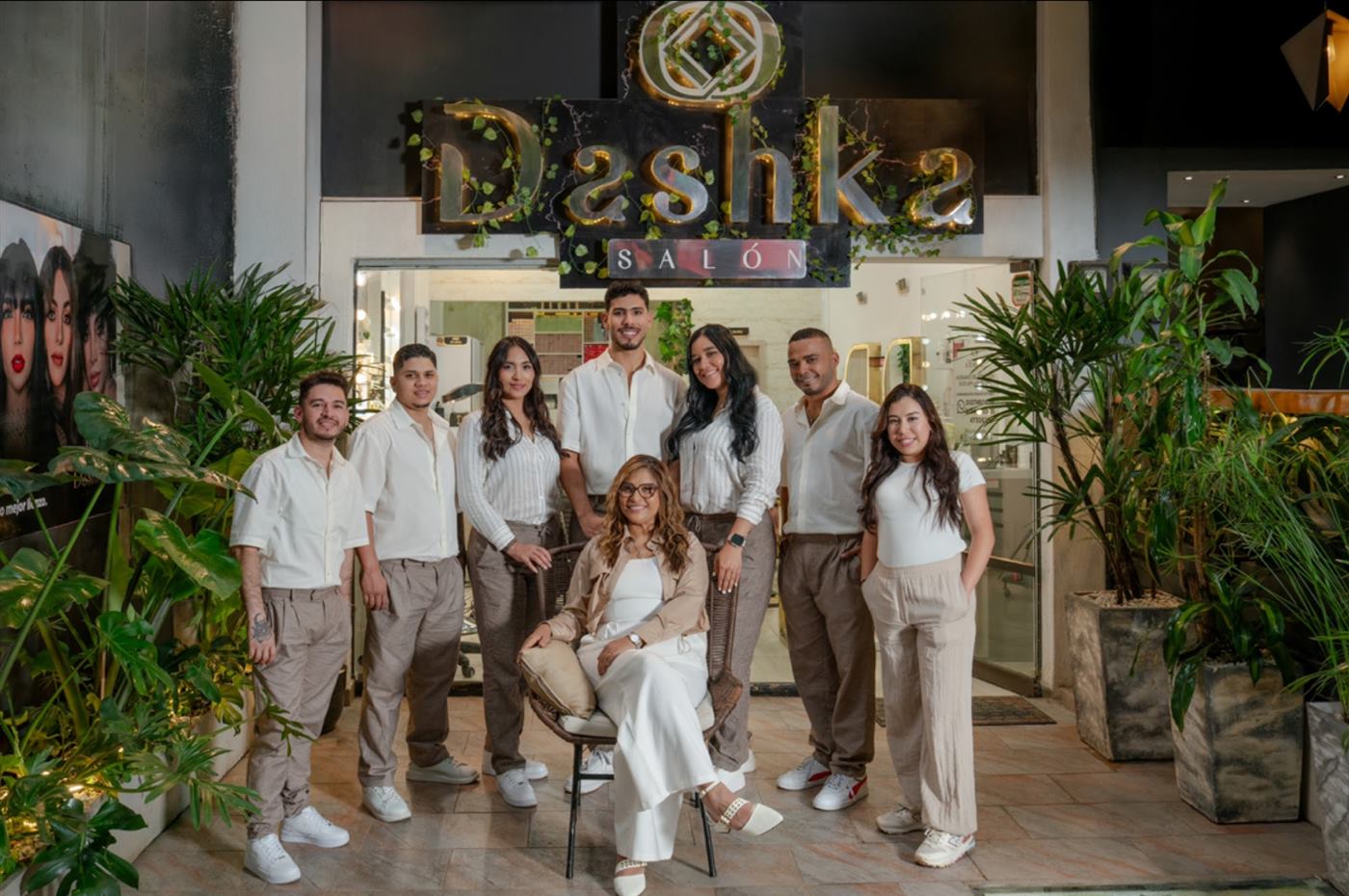 El equipo de Dashka Salón frente al letrero dorado y la hiedra de la entrada