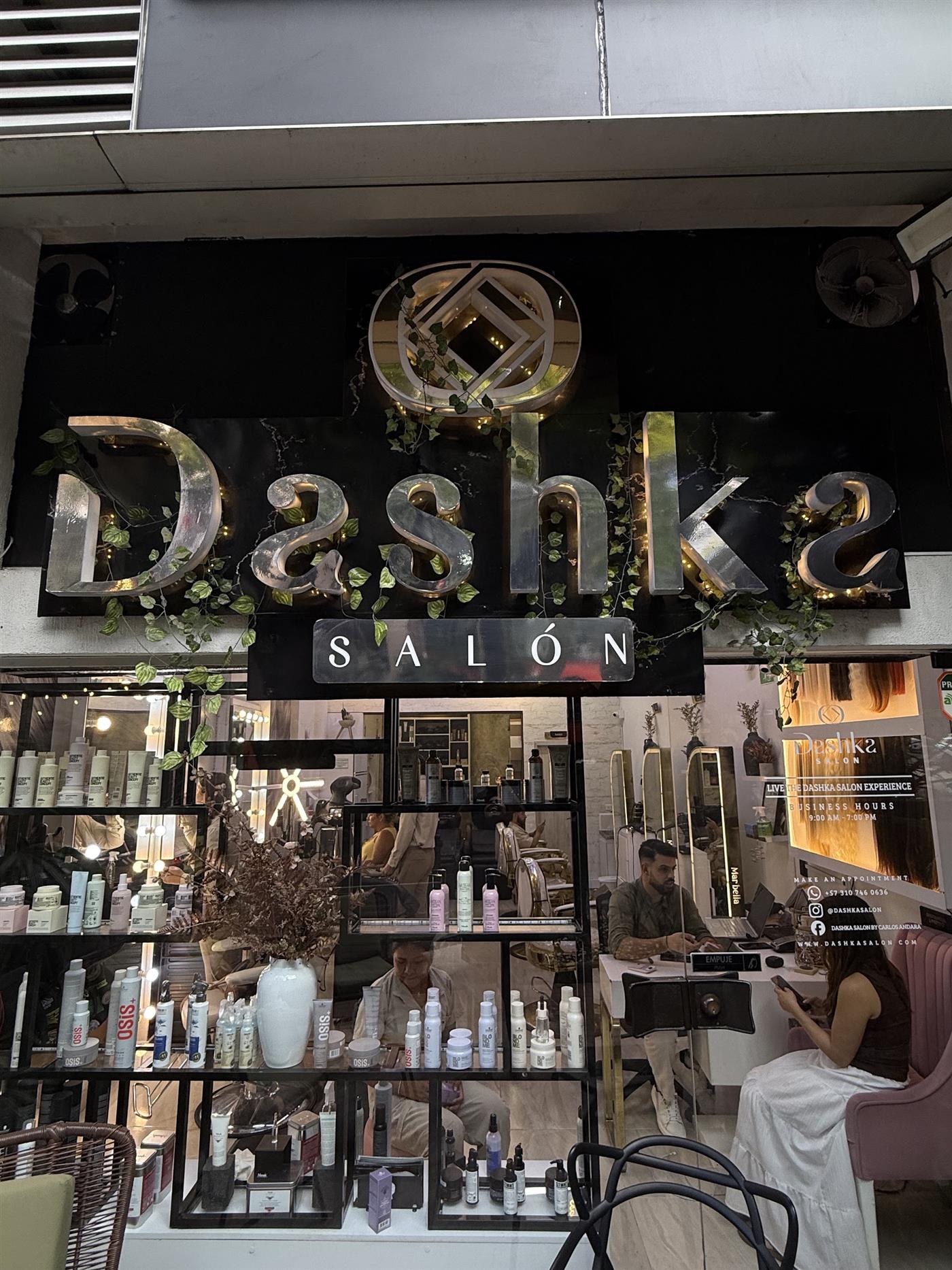 Letrero dorado de Dashka Salón sobre mármol negro